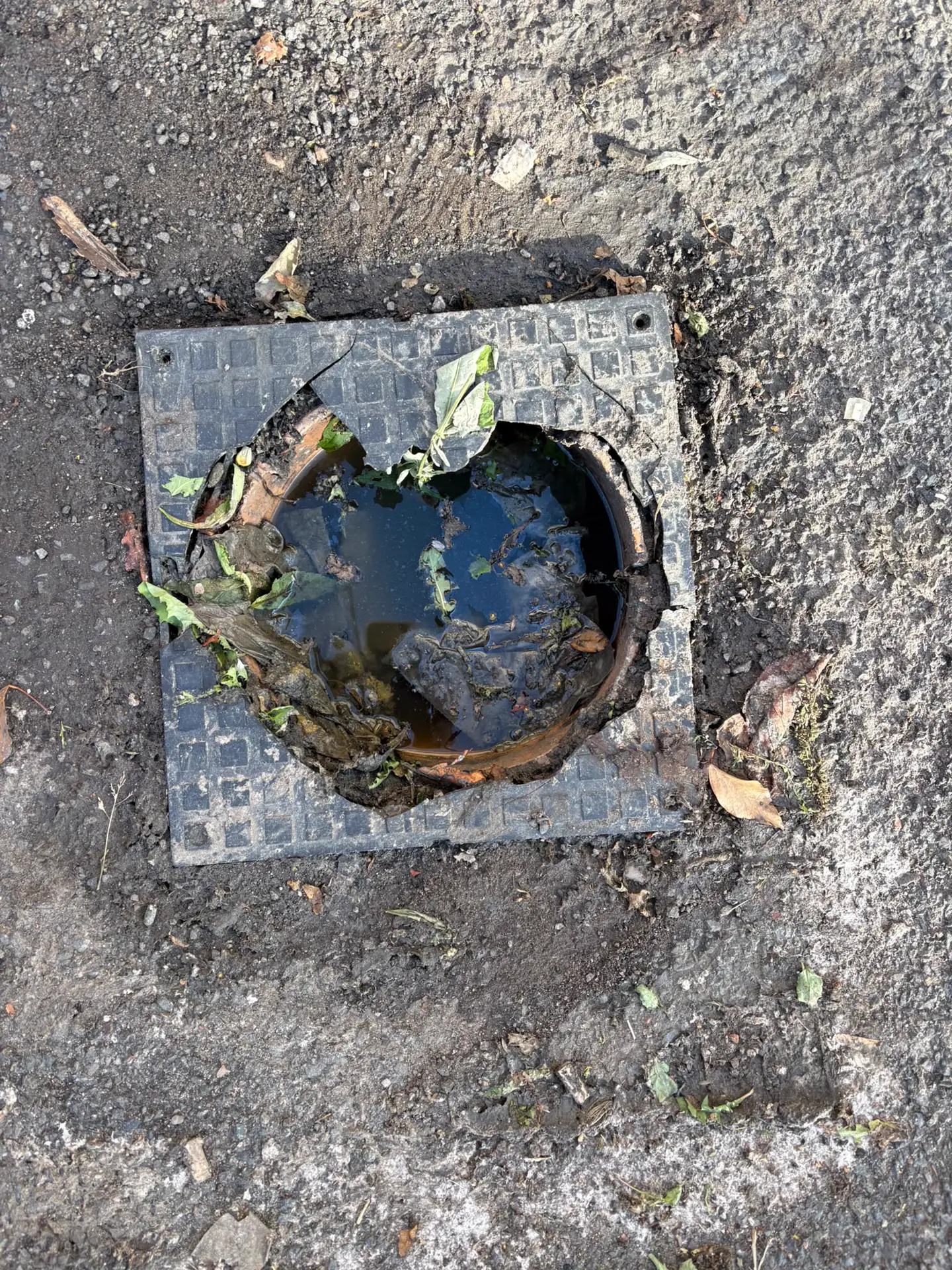 Cracked plastic manhole cover with a hole through it