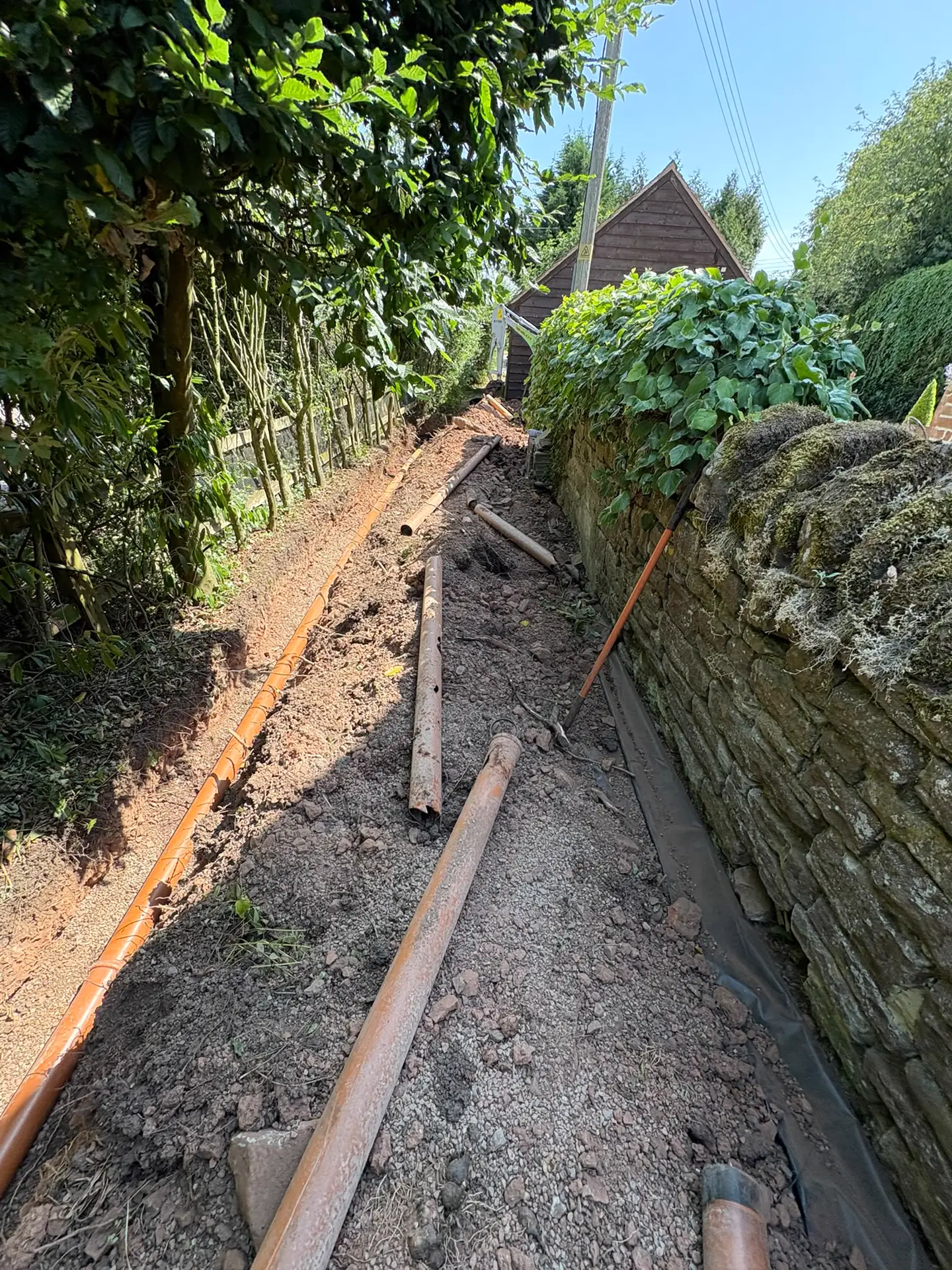 Old rusted pipework lifted out alongside the new drainage run