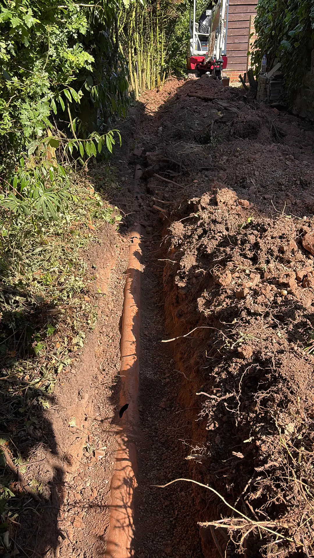 Trench with new pipework laid along the length of the run